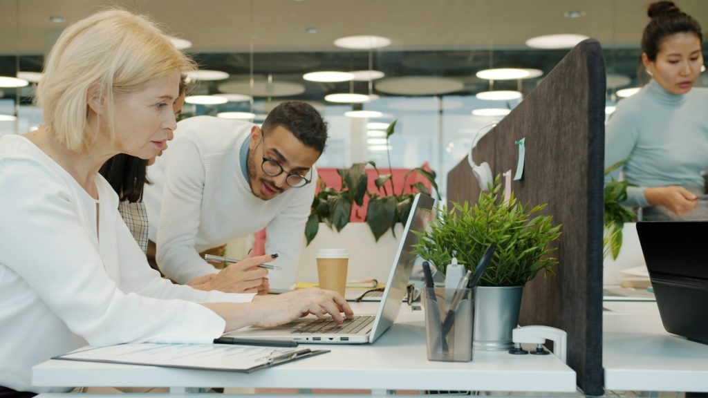 Colleagues collaborating on a digital project in an open office