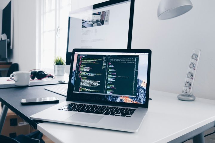 Laptop displaying web development code in a modern workspace